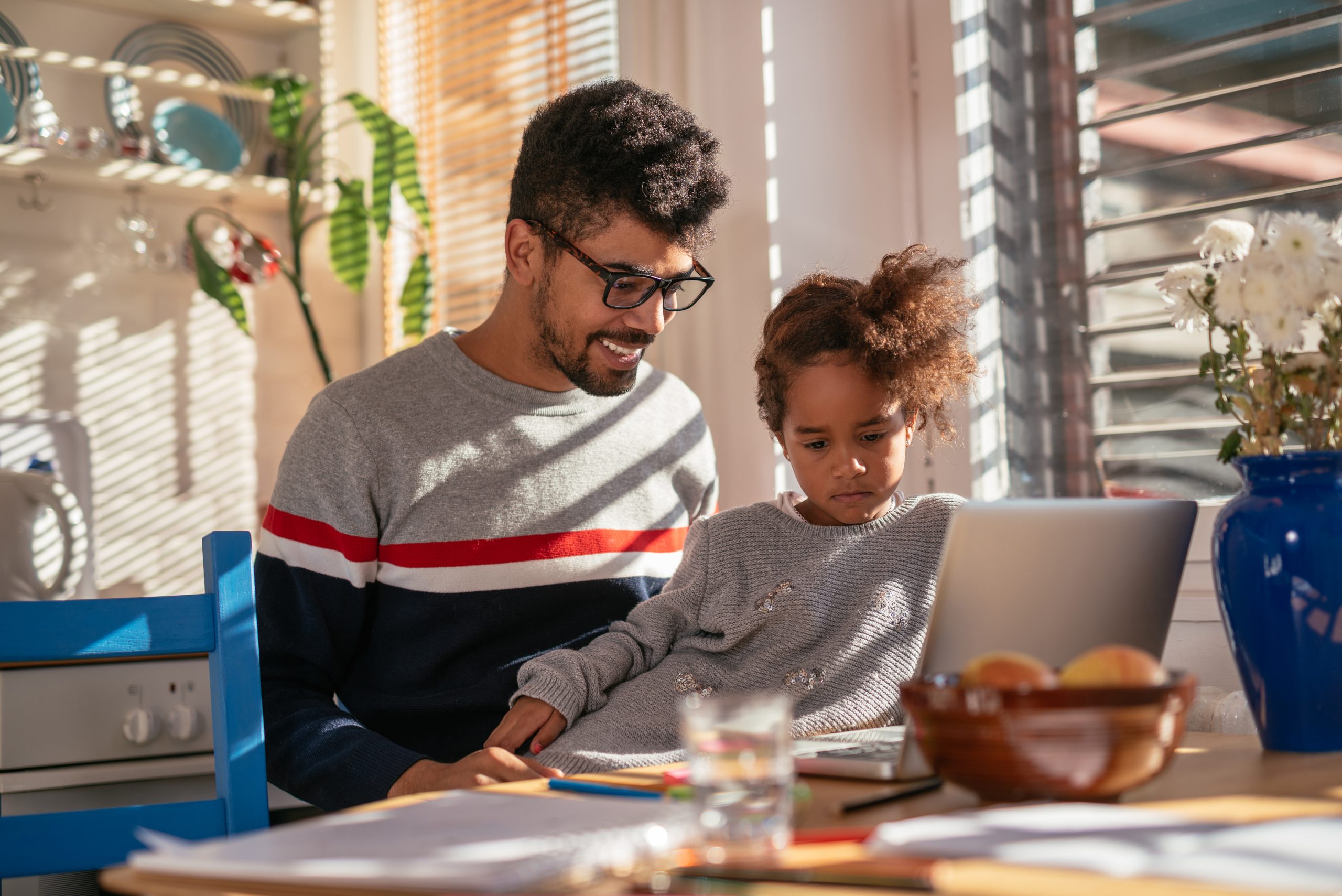 Dad and daughter learning together on a computer.