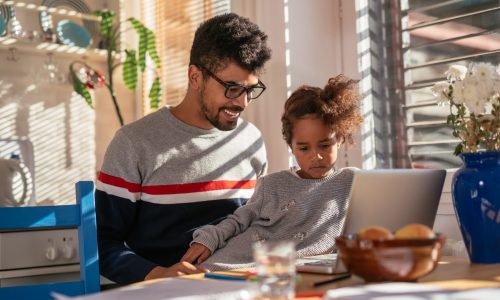 Dad and daughter learning together on a computer.